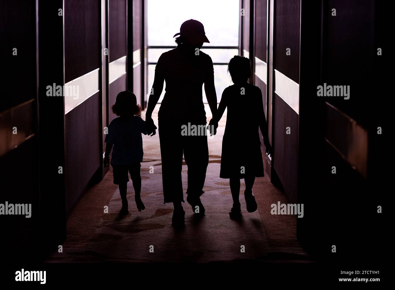 Adulto con bambini. Silhouette. Una donna che tiene per mano un bambino e una ragazza. Un concetto di famiglia dei genitori. Foto Stock