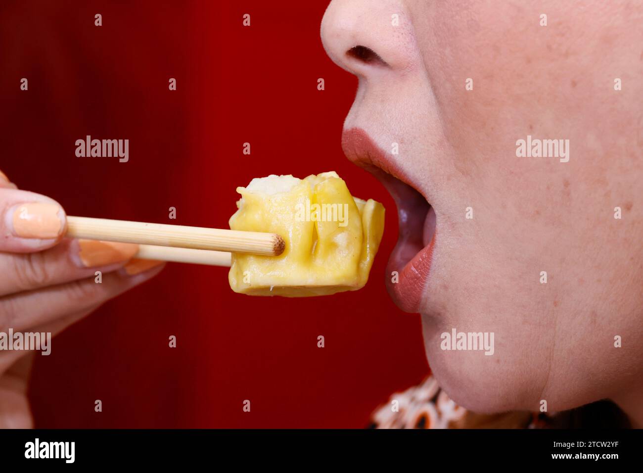 Donna che mangia Dim Sum. Primo piano sulle bacchette. Foto Stock
