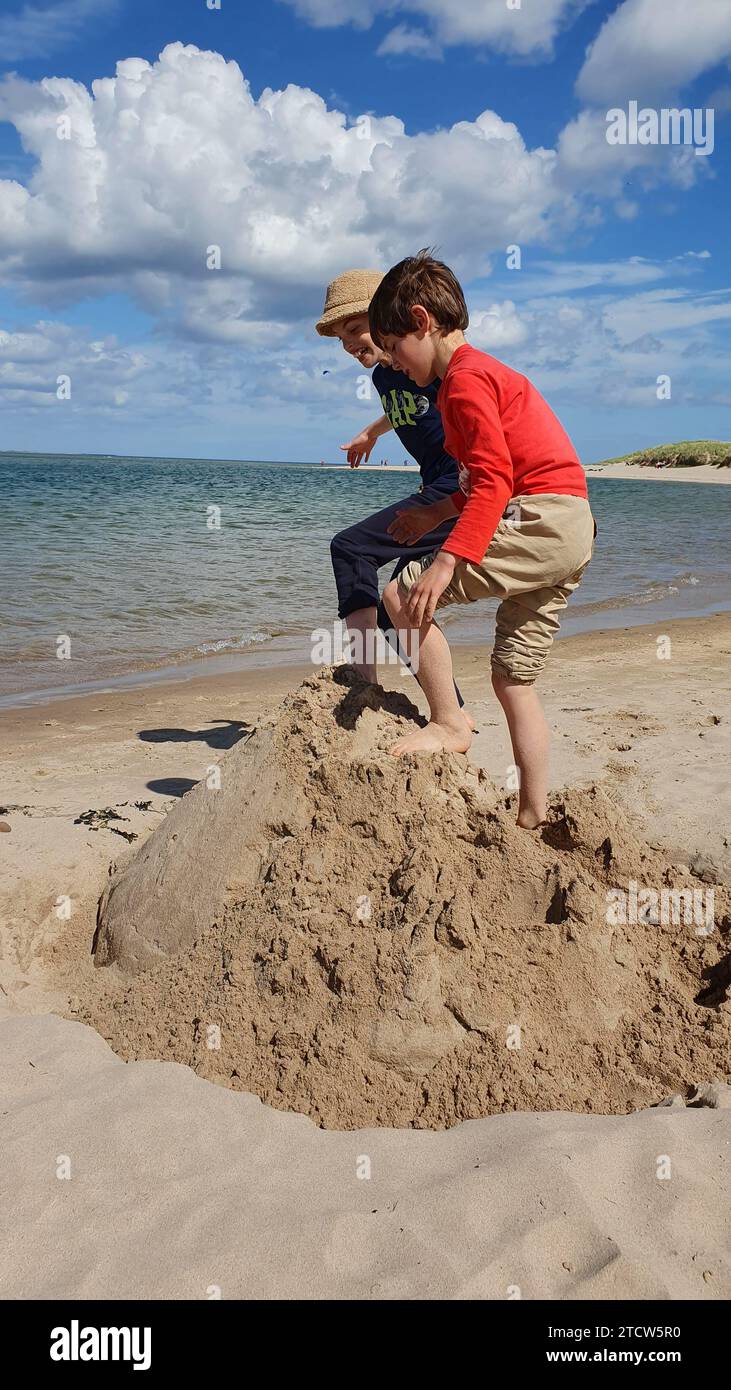 Due ragazzini che giocano sulla spiaggia di Northumberland Foto Stock