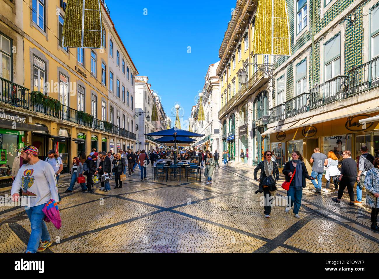La famosa via Rua Augusta, piena di negozi e ristoranti che si godono i negozi, i ristoranti e i caffè sul marciapiede di Lisbona, Portogallo. Foto Stock