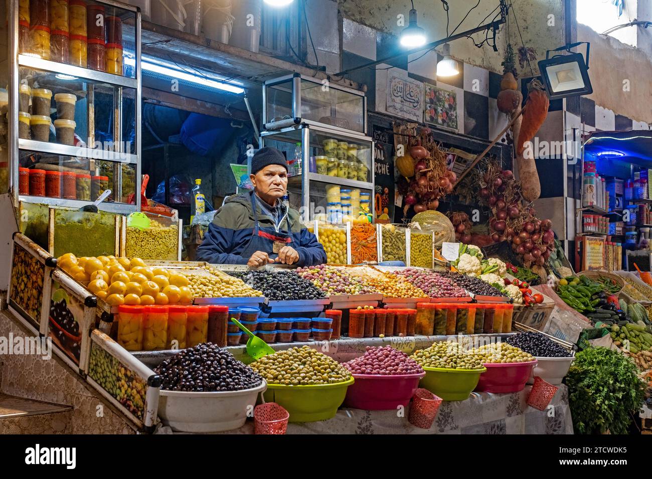 Venditore marocchino che vende olive da tavola al mercato alimentare della città di Meknes, Fez-Meknes, Marocco Foto Stock