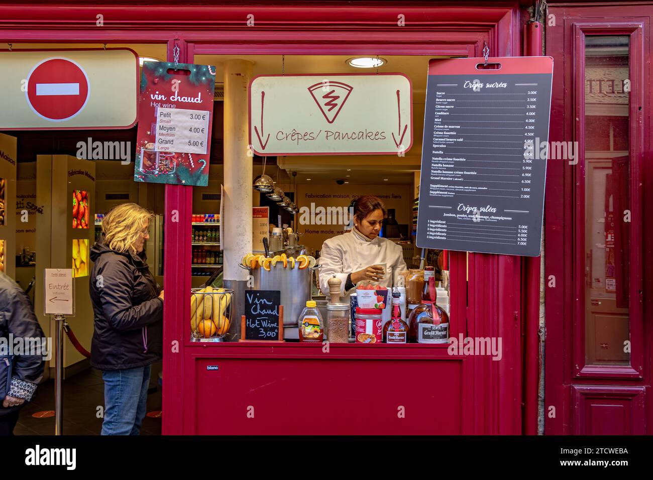 Una donna che compra VIN brulé o Vin Chaud al tutti sensi, un piccolo caffè in Rue Norvins, Montmartre, nel 18° arrondissement di Parigi, Francia Foto Stock