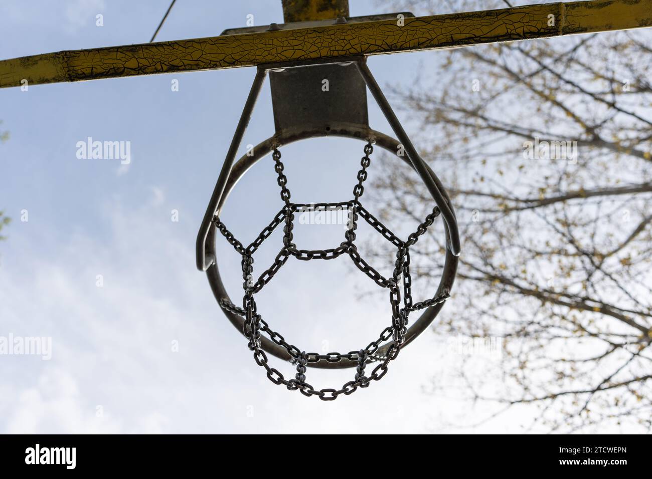Un canestro da basket in ferro all'aria aperta su uno sfondo blu. Canestro da basket con rete di ferro Foto Stock
