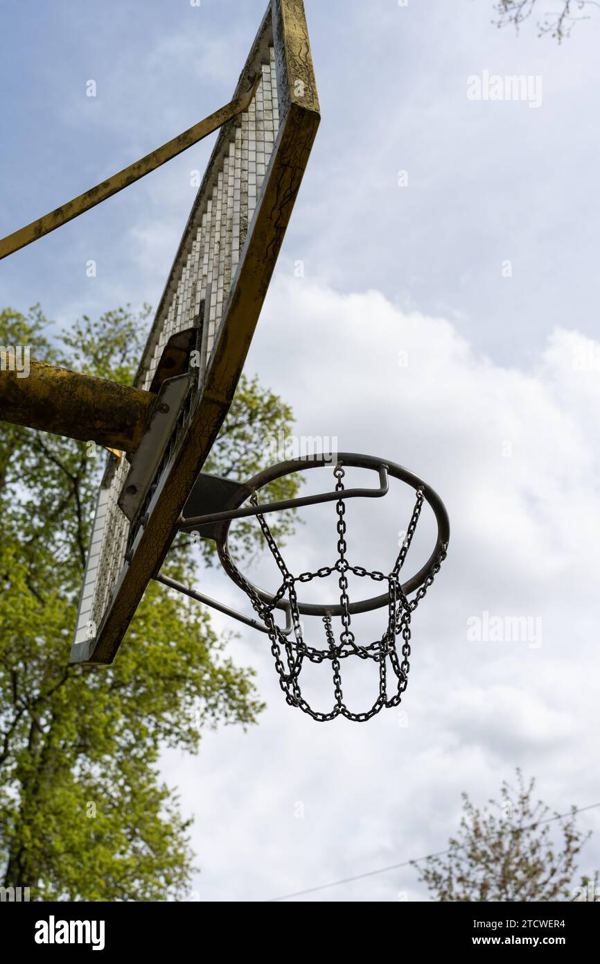 Un canestro da basket in ferro all'aria aperta su uno sfondo blu. Canestro da basket con rete di ferro Foto Stock