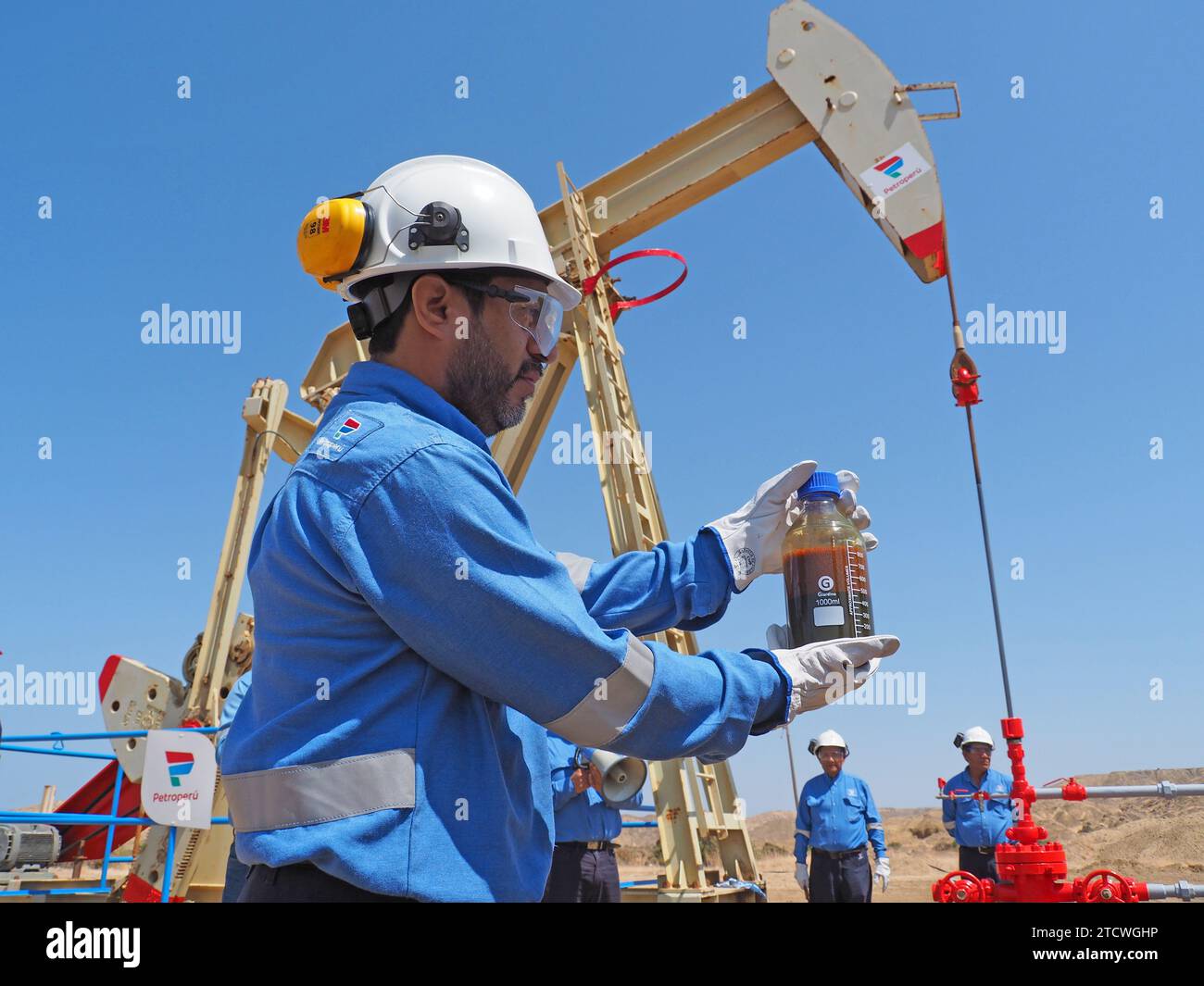 Personale della Petroperu che estrae un campione di greggio da un pozzo petrolifero che rifornisce gli impianti della raffineria New Talara, gestita da Petroperu, con la capacità di processare fino a 95.000 barili di petrolio al giorno e che è stato costruito ad un costo di oltre 5.000 milioni di dollari. Foto Stock