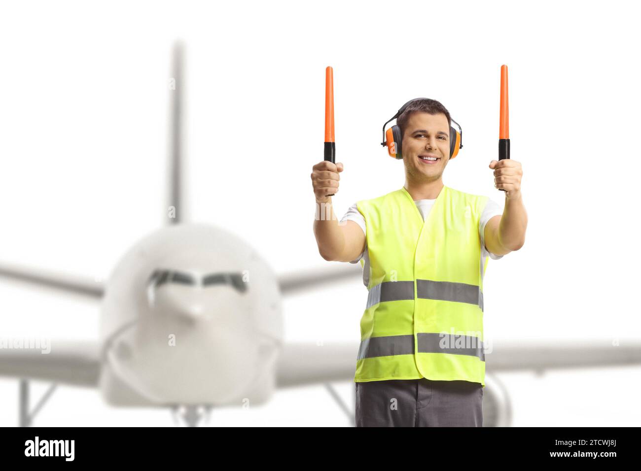 Marshaler di aerei che segnalano con bacchette di fronte a un aereo Foto Stock