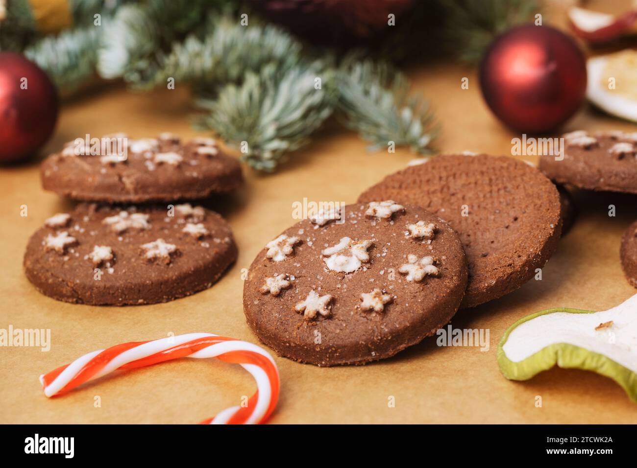 Zenzero natalizio, canna da zucchero, frutta secca e bauble su sfondo di carta kraft. Primo piano. Foto Stock