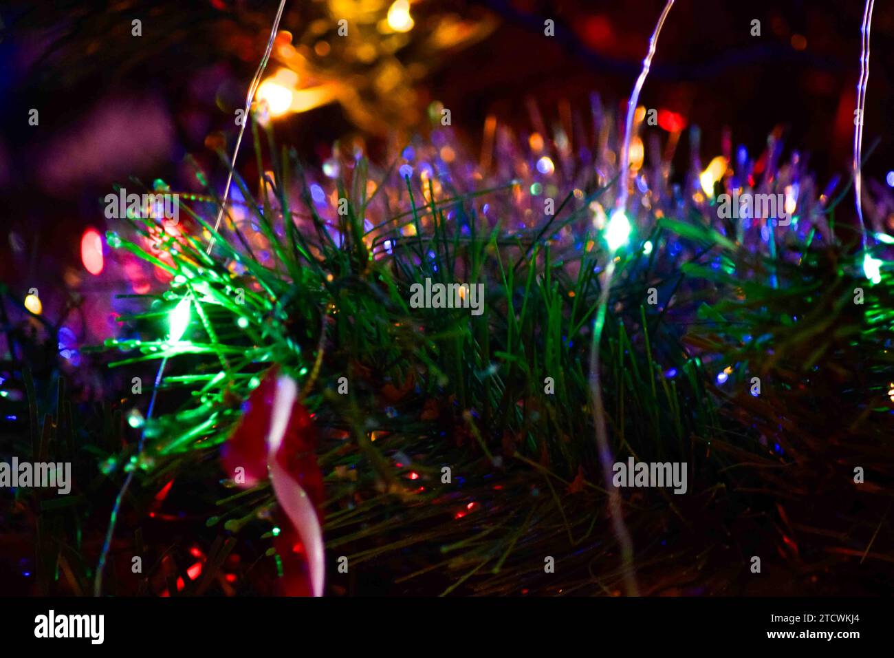 Una serie di luci natalizie, ornamenti e tinsel su un albero. Tutte le immagini scelte sono state modificate con Lightroom Classic. Foto Stock