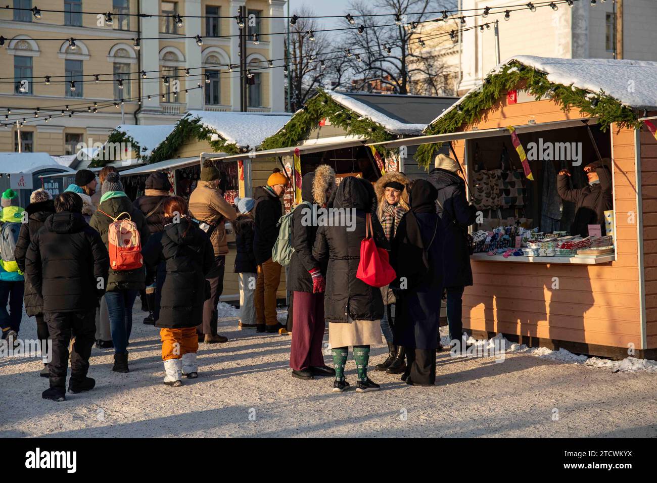 Persone e chalet di mercato al Tuomaan Markkinat o al mercato di Natale di Helsinki in Piazza del Senato a Helsinki, Finlandia Foto Stock