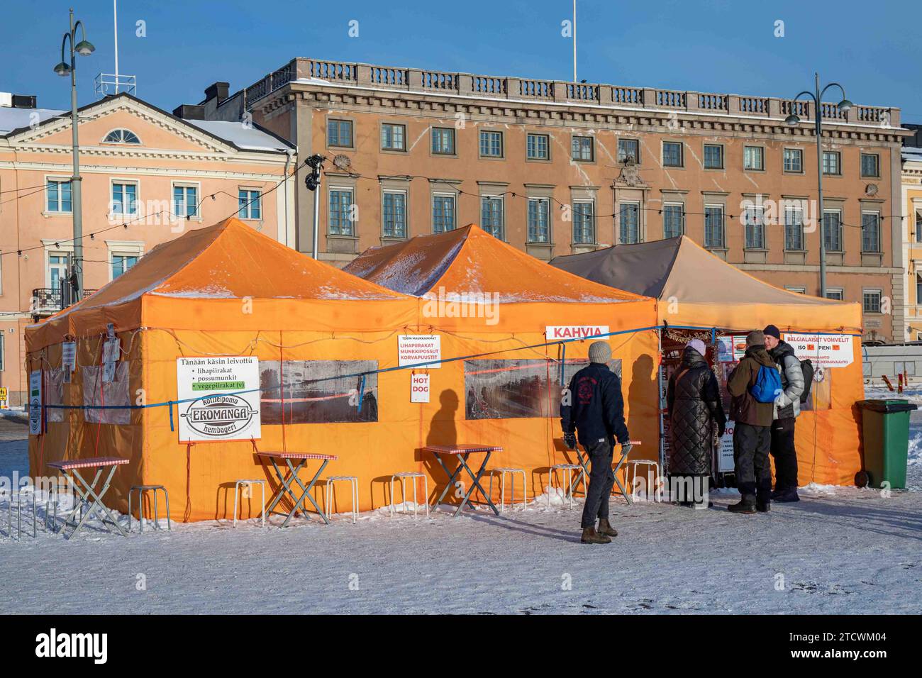 La gente fa la fila per il caffè della tenda arancione sulla piazza del mercato innevata in una soleggiata giornata invernale a Helsinki, Finlandia Foto Stock