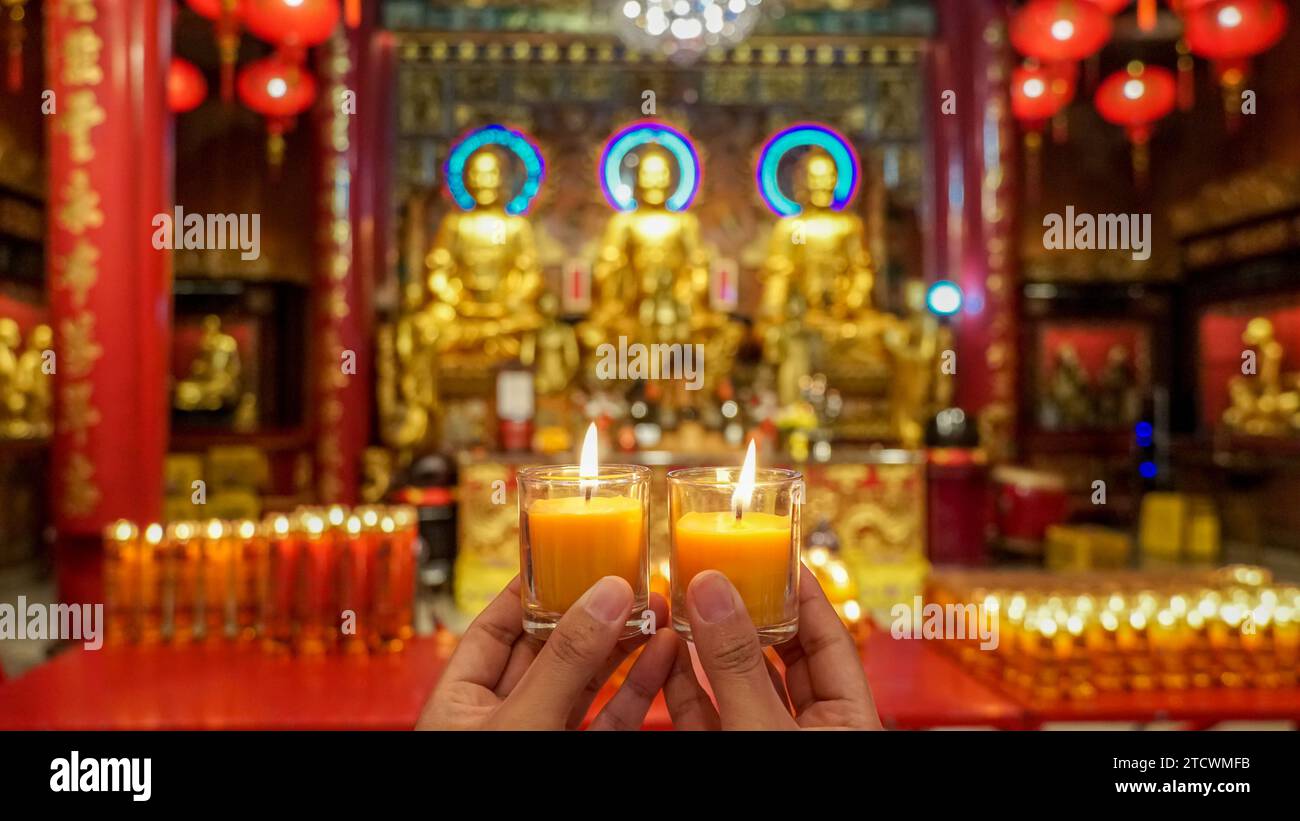 Donna asiatica che prega candele bianche buddiste per rendere omaggio al capodanno cinese al Tempio del Drago Kammalawat o Wat Mangkorn o Wat Lengnoeiy Foto Stock