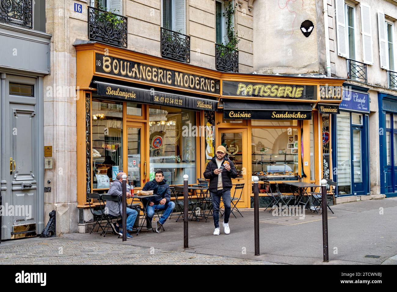 Persone sedute fuori Boulangerie moderne, un panificio artigianale usato nella serie TV Emily a Parigi nel V arrondissement di Parigi, Francia Foto Stock