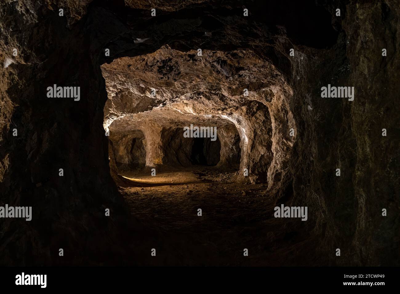 Antico tunnel sotterraneo poco illuminato con pareti strutturate, che evocano mistero ed esplorazioni storiche. Foto Stock
