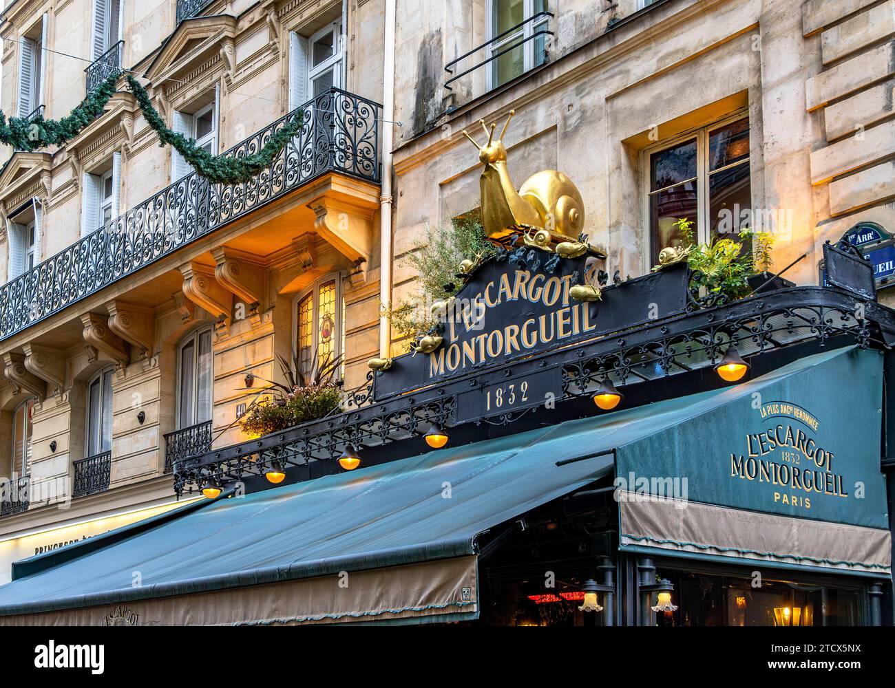 Una grande lumaca dorata sopra l'entrata dell'Escargot Montorgueil , classico ed elegante ristorante francese in Rue Montorgueil a Parigi , Francia Foto Stock