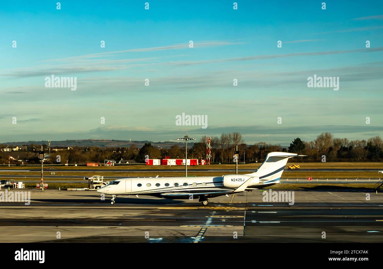 Un elegante jet privato Gulfstream parcheggiato sull'asfalto dell'aeroporto di Dublino, Irlanda, durante l'ora d'oro. Foto Stock
