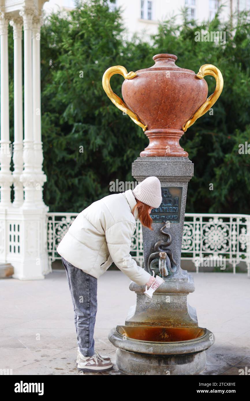 Le ragazze bevono l'acqua minerale della sorgente dei serpenti nella cittadina di Karlovy Vary Foto Stock