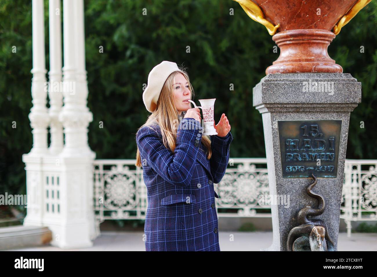 La ragazza beve acqua minerale nella cittadina di Karlovy Vary Foto Stock
