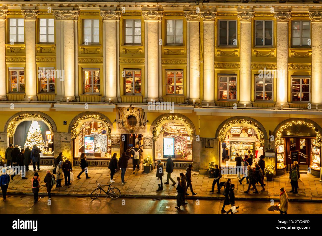 Feinkost Dallmayr, Kunden vor den weihnachtlich erleuchteten Schaufenstern in der Dienerstraße, München, Dezember 2023 Deutschland, München, Dezember 2023, Münchner beim Abendbummel in der Dienerstraße, vor den weihnachtlich erleuchteten Schaufenstern von Alois Dallmayr, Dallmayr ist ein Münchner Traditionsgeschäft, bekannt für Feinkost und Delikatessen, Zentrum, Passanten, festlich leuchtende Hausfassade, Weihnachtskonsum, Weihnachtseinkäufe, Shopping, Donnerstag, Stadt, Inverno, Bayern, bayerisch, Querformat, *** Feinkost Dallmayr, clienti di fronte alle vetrine dei negozi illuminati a Natale a Diene Foto Stock