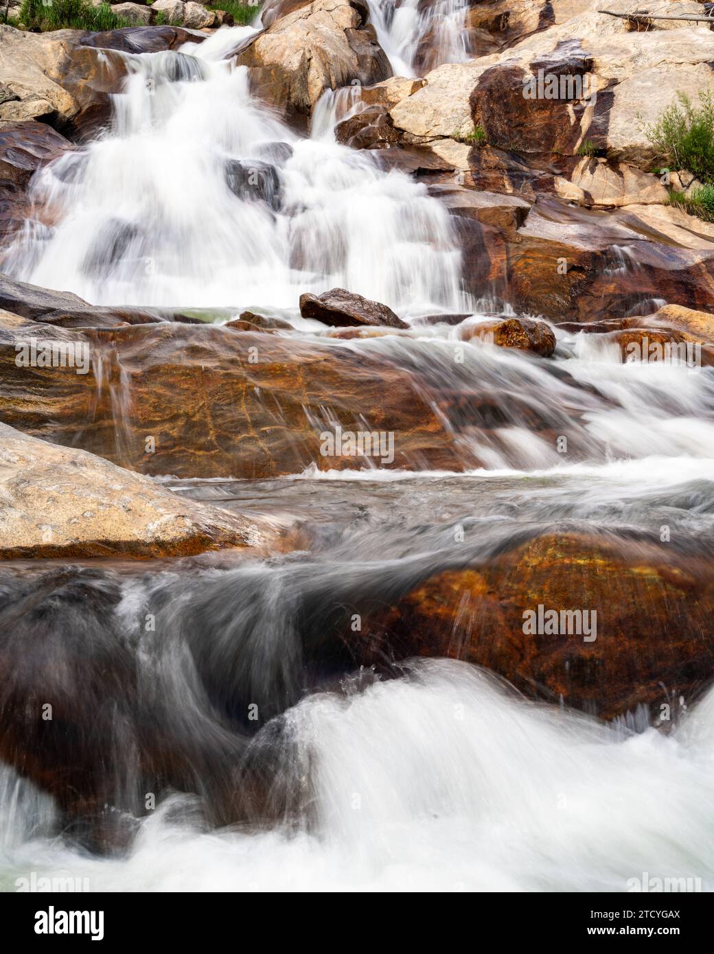 Maestose cascate su massi lisci nel parco nazionale delle Montagne Rocciose. Foto Stock