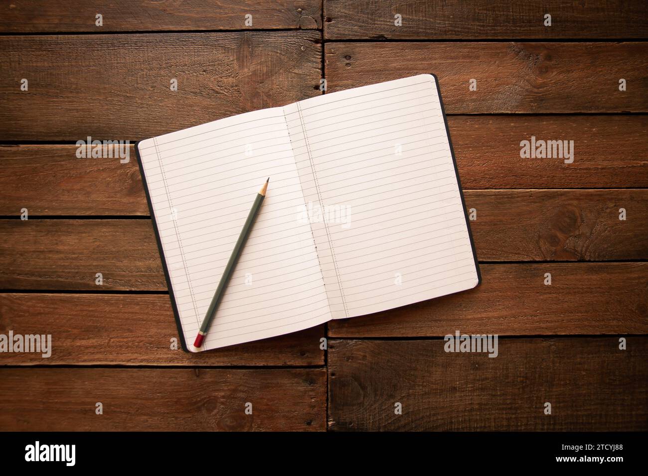 Aprire il notebook e la matita su un rustico asse in legno vintage Foto Stock