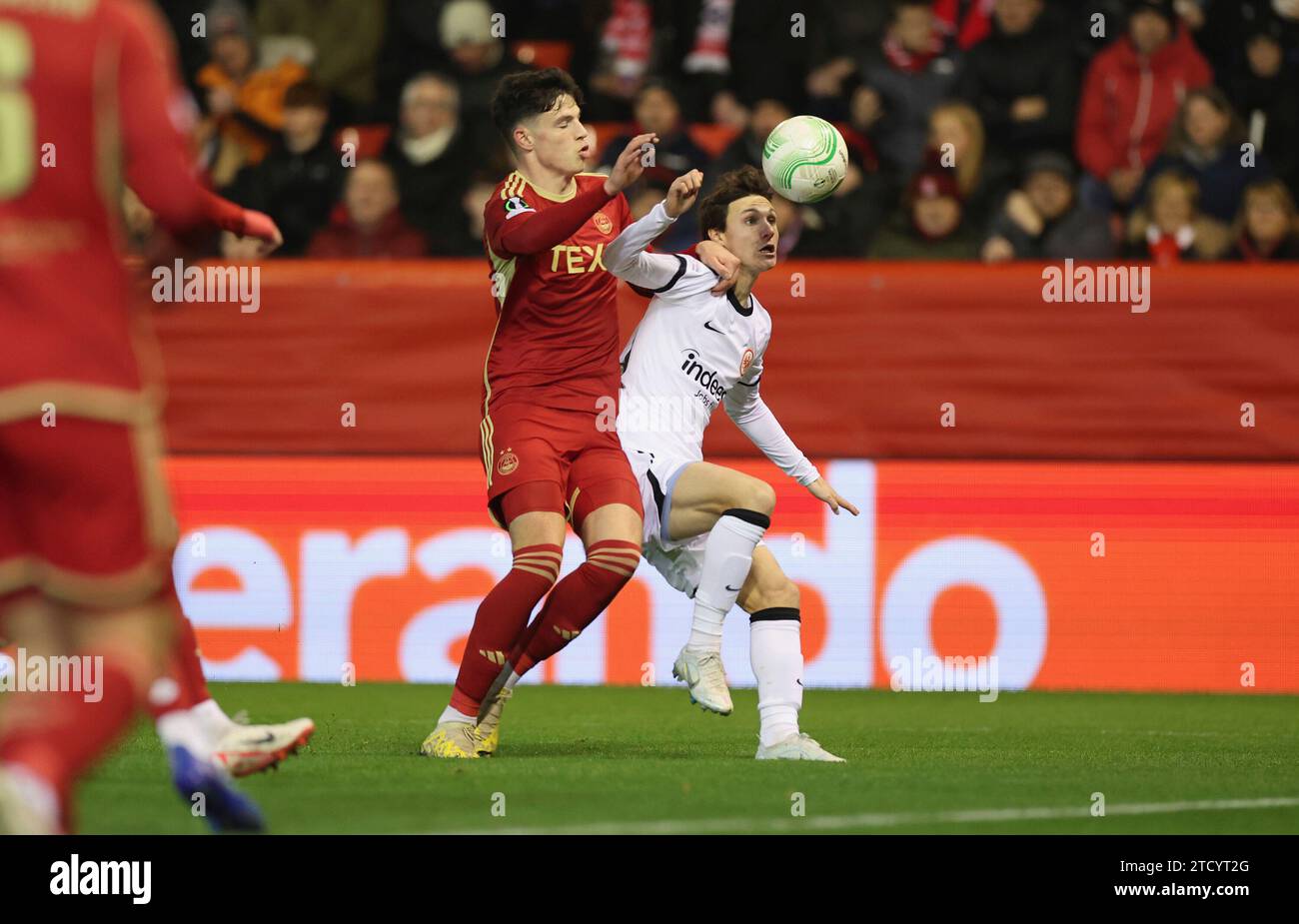 14.12.2023, Fussball UEFA Europa Conference League, Aberdeen FC - Eintracht Frankfurt, emonline, emspor, v.l., Angus MacDonald (Aberdeen FC), Paxten Aaronson (Eintracht Francoforte) LE NORMATIVE DFL/DFB VIETANO QUALSIASI USO DI FOTOGRAFIE COME SEQUENZE DI IMMAGINI E/O QUASI-VIDEO. xdcx Foto Stock