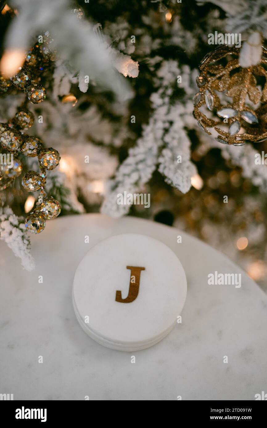 La lettera J Coaster sotto l'albero di natale Foto Stock