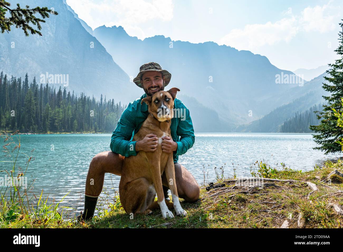 Escursionista in posa con il bellissimo Dog Lakeside Foto Stock