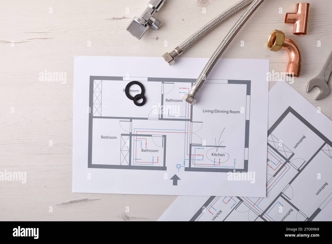 Progettazione e sviluppo di installazioni e riforme dell'acqua nelle case con diagrammi e piani su un tavolo da ufficio e vari elementi materiali. Foto Stock