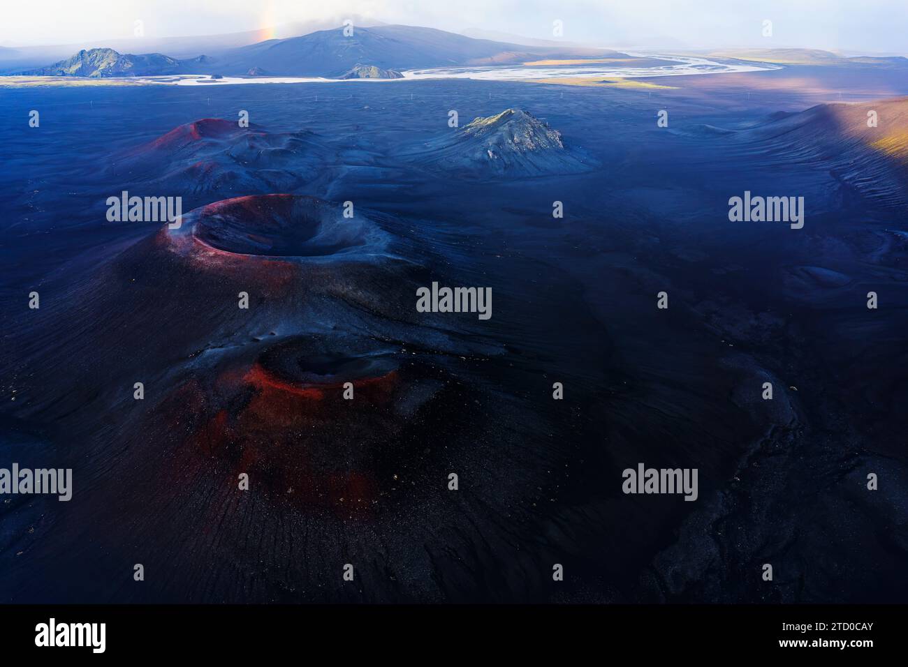Una ripresa aerea cattura le consistenze e i colori drammatici del terreno vulcanico dell'Islanda, con formazioni rocciose e sfumature sottili sotto un vasto cielo Foto Stock