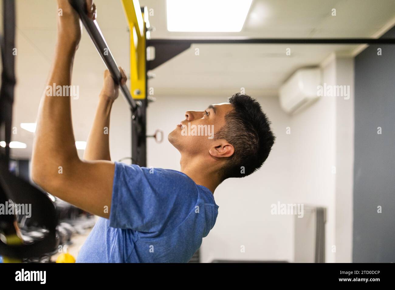 Un giovane concentrato che fa dei tiri in una palestra tecnica Foto Stock