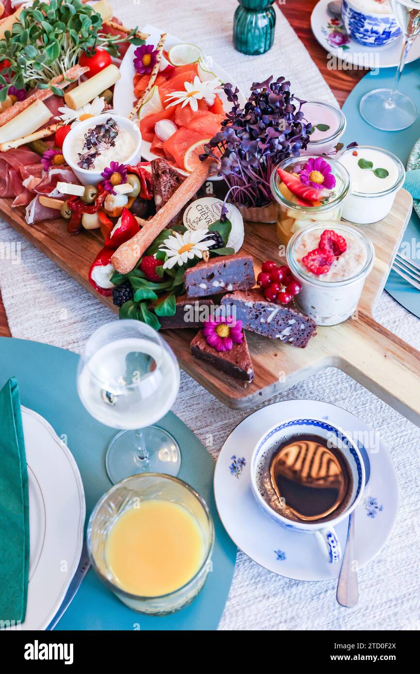 Elegante buffet di brunch con una varietà di cibi e bevande gourmet su un tavolo decorato. Foto Stock