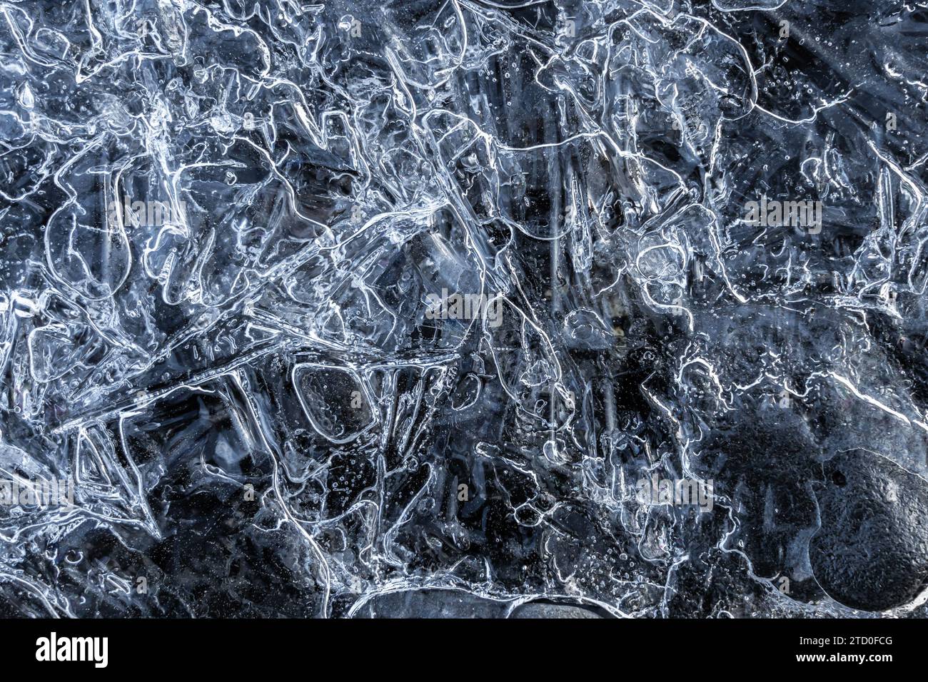Un primo piano di una superficie ghiacciata mostra intricati modelli di ghiaccio con aree chiare e opache, catturando la bellezza naturale e la complessità del ghiaccio. Foto Stock