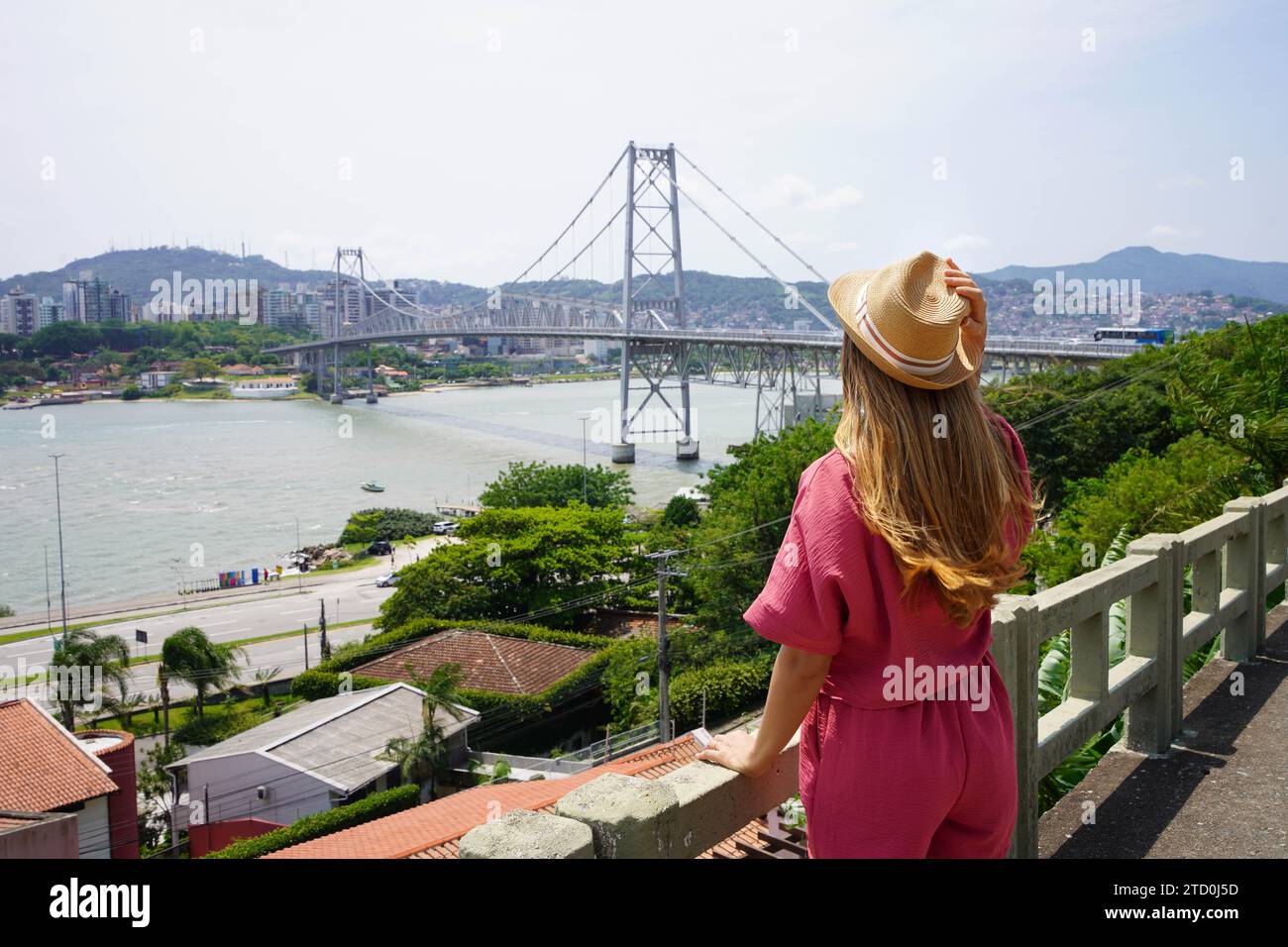 Turismo a Florianopolis, Brasile. Vista posteriore della bellissima ragazza viaggiatrice che si gode la vista del ponte Hercilio Luz a Florianopolis, Brasile. Vacanze estive Foto Stock
