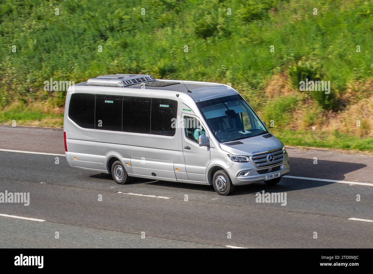 MERCEDES-BENZ Sprinter argento, minibus CE da 2143 cc, noleggio autobus urbano, minibus di lusso, furgone da 16 posti, in viaggio sull'autostrada M61, Regno Unito Foto Stock