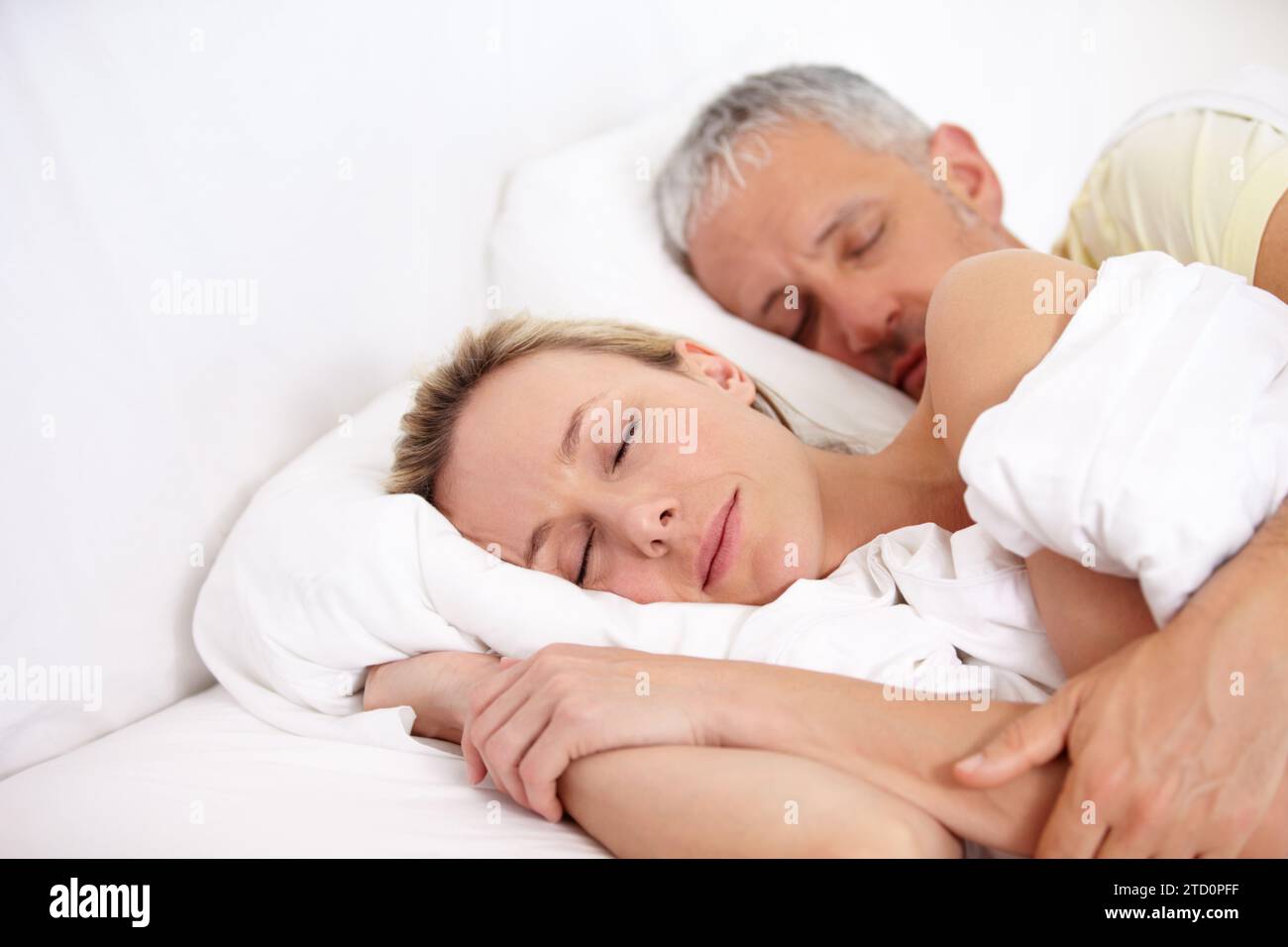 Coppia affamata, stanca e matura che dorme a letto per coccolarsi insieme il fine settimana mattina a casa. Calmo, pacifico e uomo e donna che fanno un pisolino e.. Foto Stock