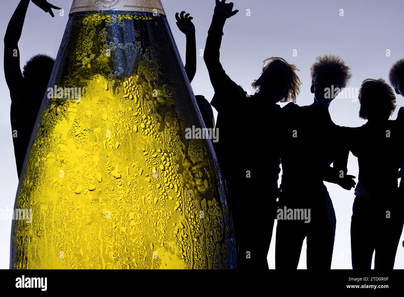 Una bottiglia dewy di bevanda alcolica con silhouette di gente danzante sullo sfondo Foto Stock