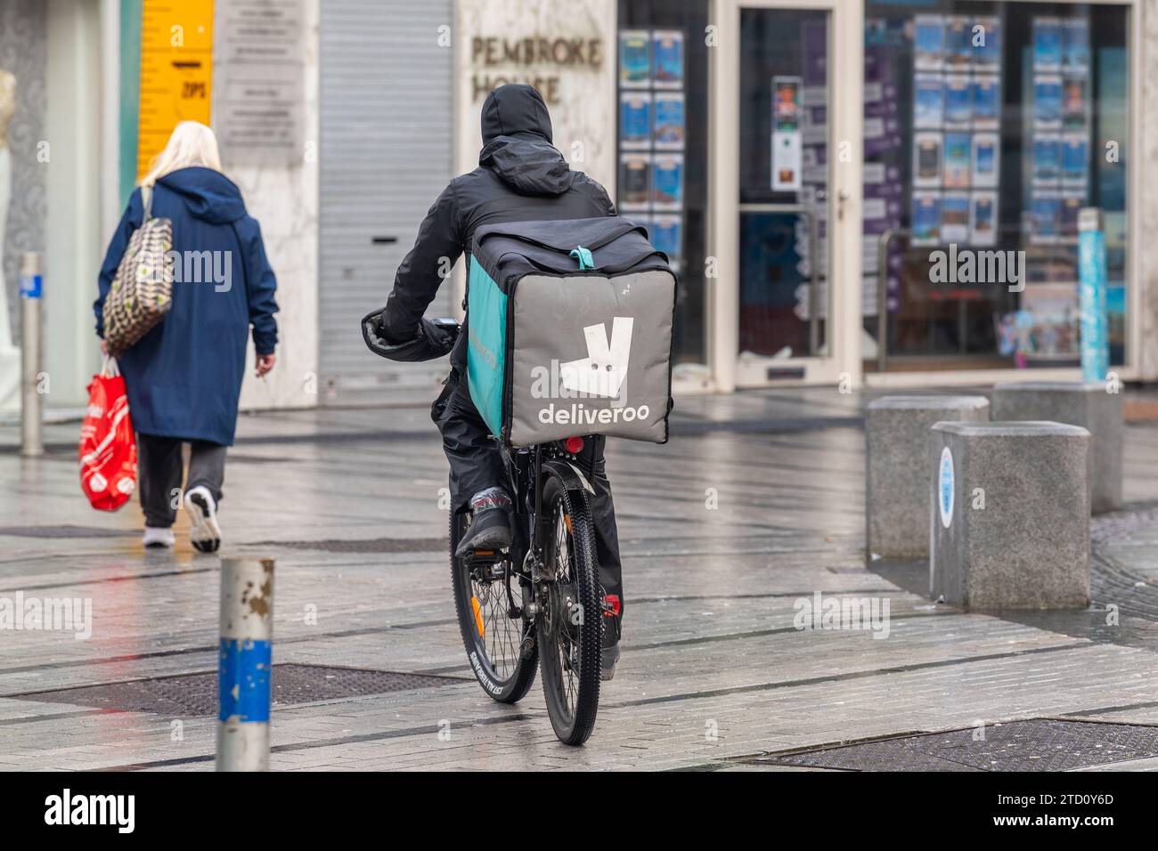Deliveroo rider su una push bike che fa una consegna di cibo a Cork, in Irlanda. Foto Stock