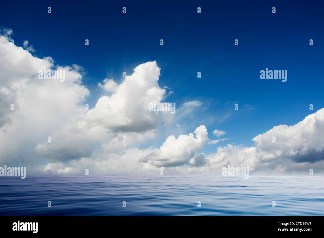mare calmo e cielo azzurro con nuvole bianche piumose Foto Stock