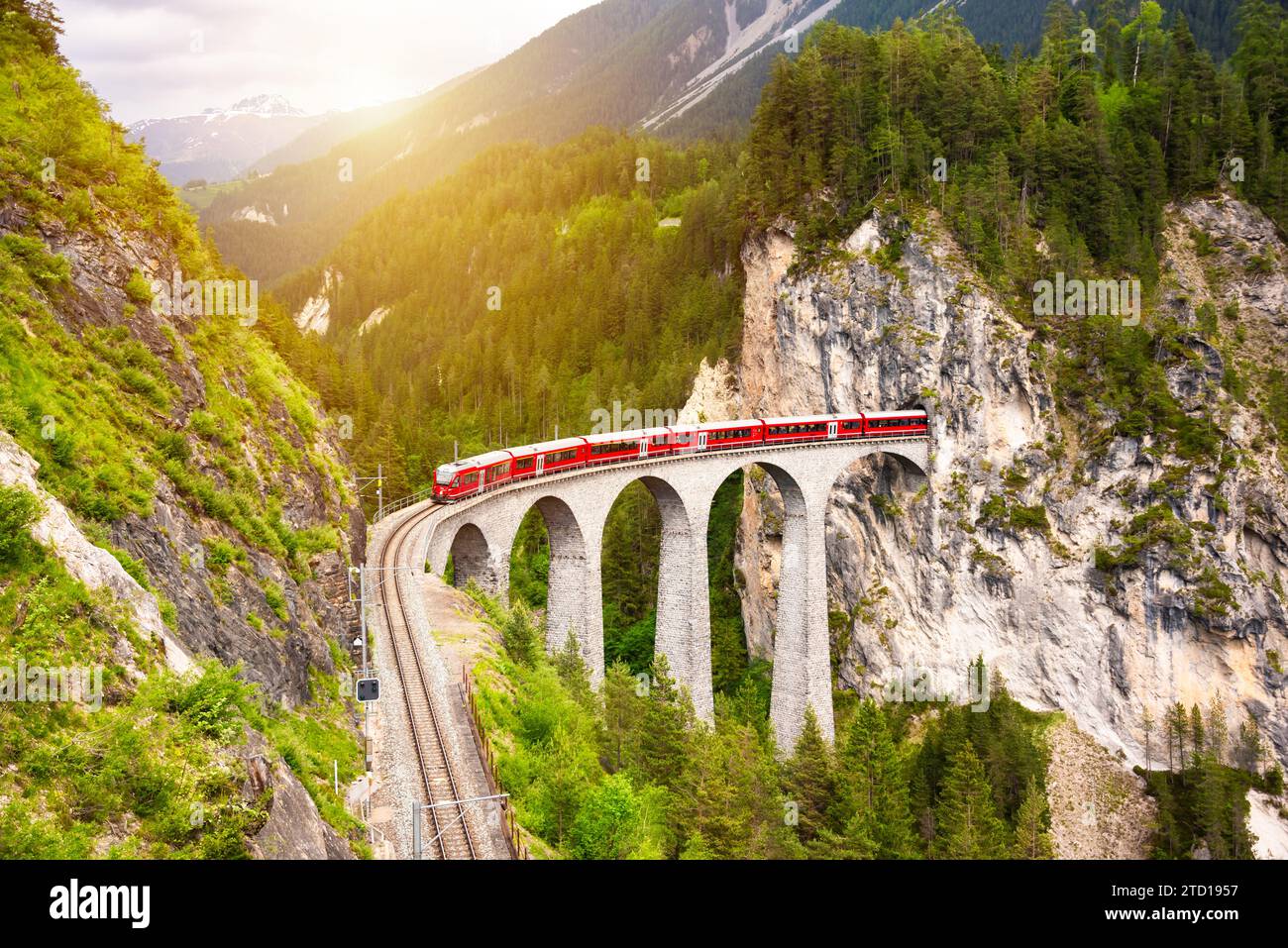 Treno rosso svizzero sul viadotto in montagna per un giro panoramico Foto Stock