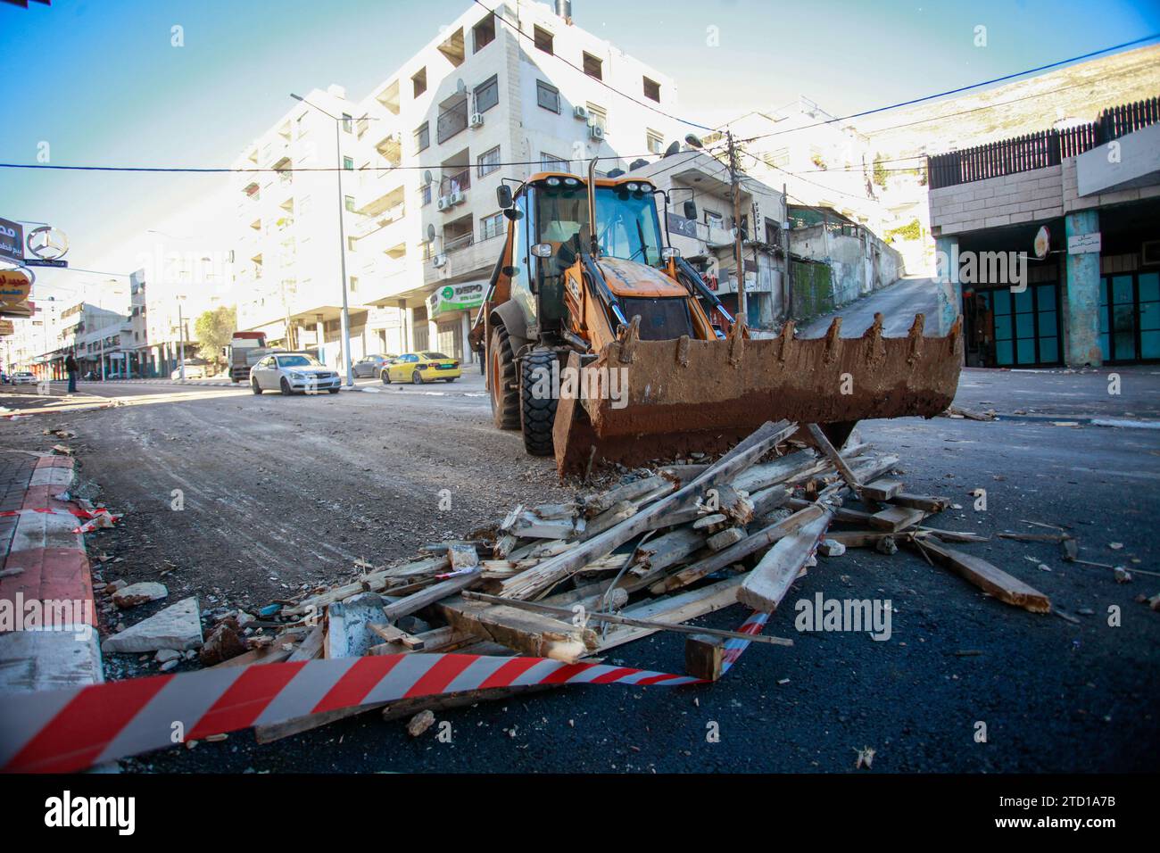 Un bulldozer palestinese rimuove le macerie dal sito di un attacco aereo israeliano contro militanti palestinesi dal campo profughi di Balata, a est della città di Nablus in Cisgiordania. Un drone israeliano ha razziato i militanti palestinesi vicino alla tomba di Giuseppe per un tentativo di assassinarli, e sono fuggiti. Non sono state riportate ferite e il raid ha causato distruzione in strada. (Foto di Nasser Ishtayeh / SOPA Images/Sipa USA) Foto Stock