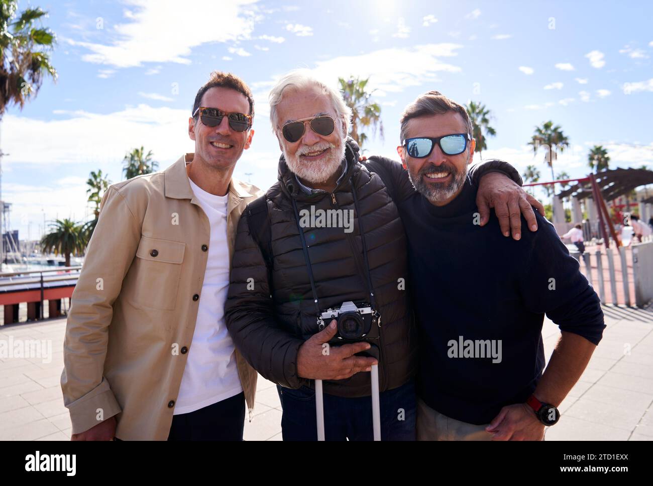 Allegro ritratto di un padre con i suoi figli adulti in vacanza, guardando la fotocamera sorridente. Foto Stock