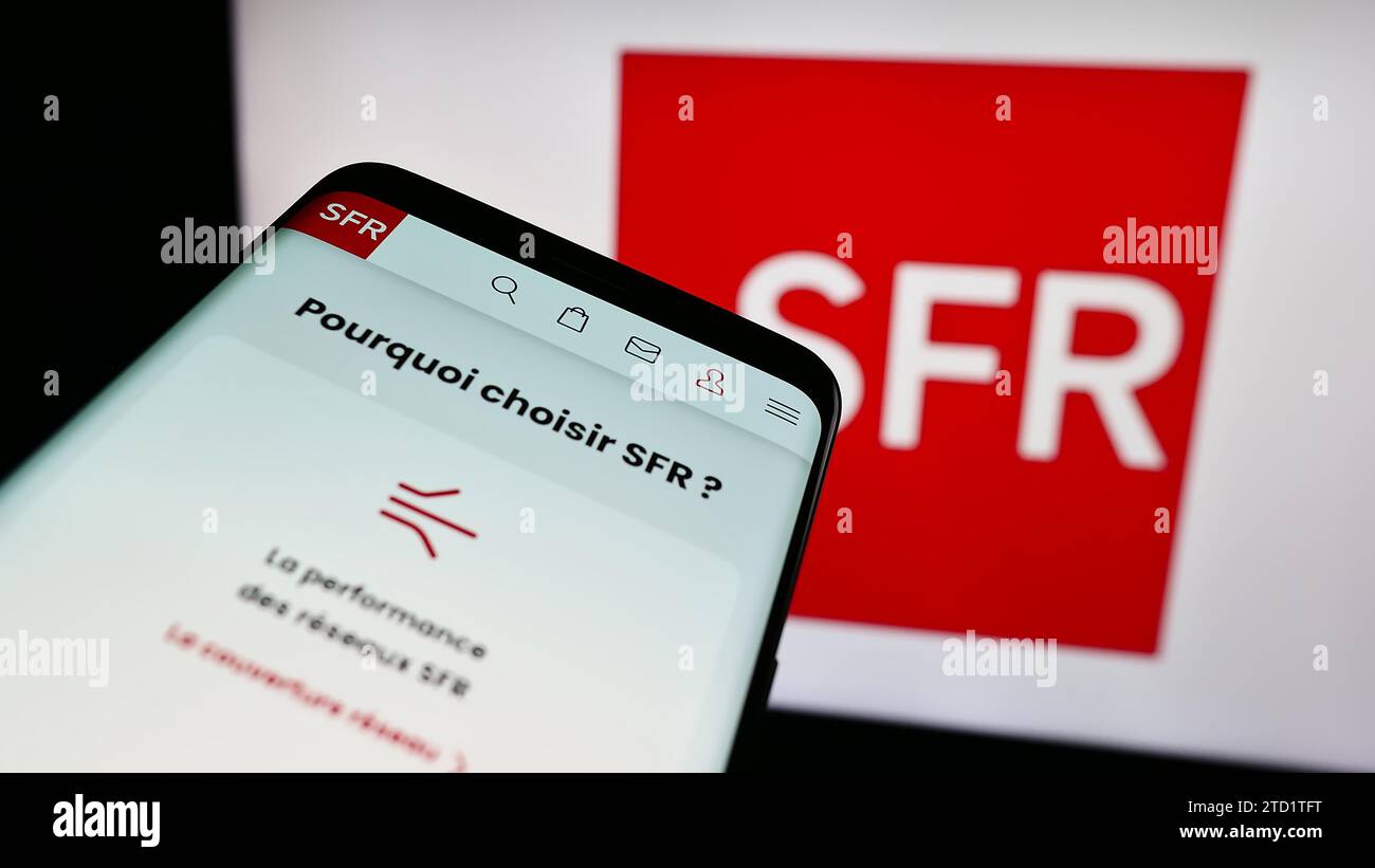 Telefono cellulare con sito web della società francese Société Francaise du Radiotéléphone (SFR) davanti al logo. Mettere a fuoco in alto a sinistra sul display del telefono. Foto Stock