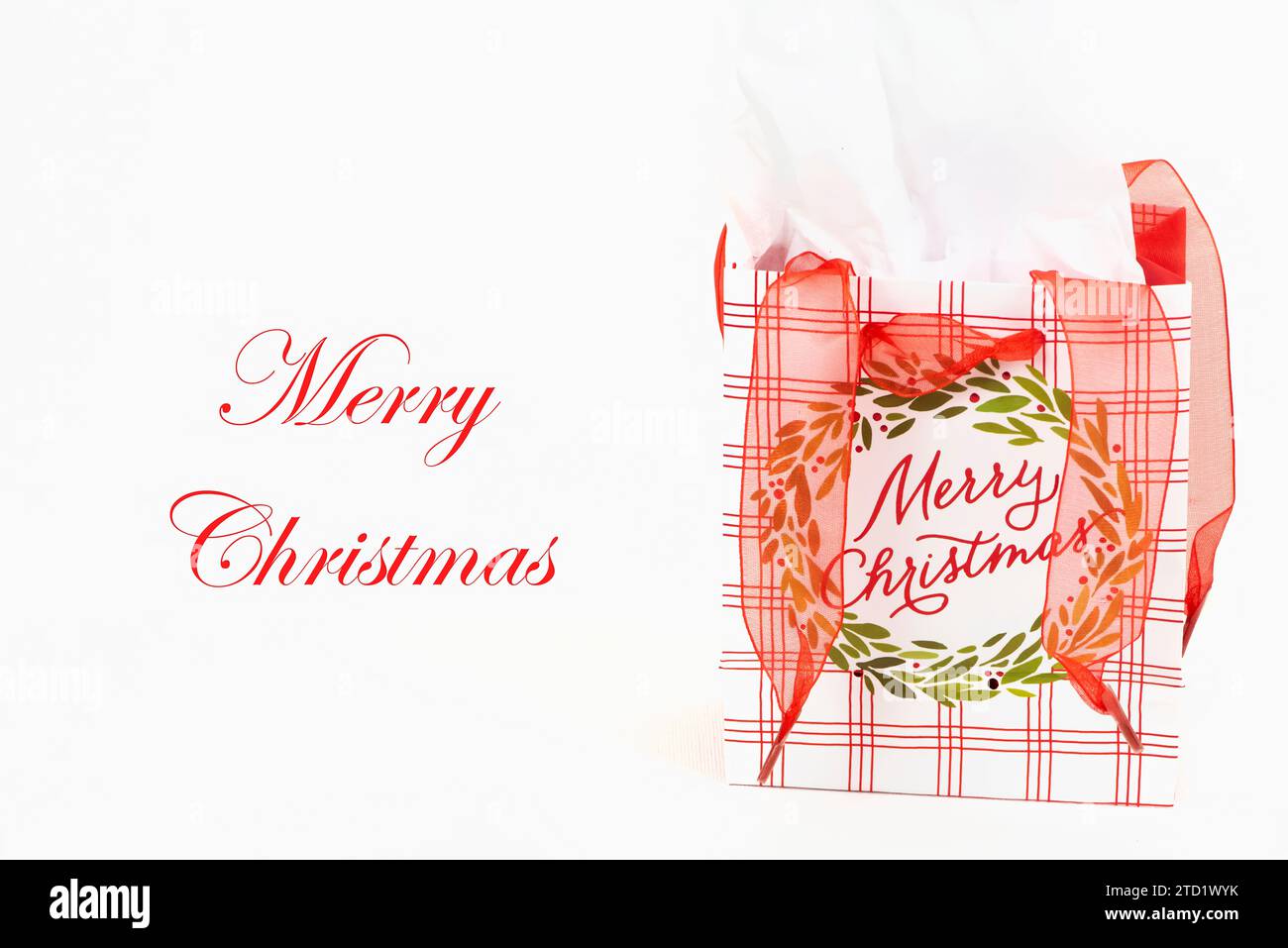 Biglietto d'auguri di buon Natale, sfondo, con borsa regalo di buon Natale con nastro rosso e carta bianca. Foto Stock