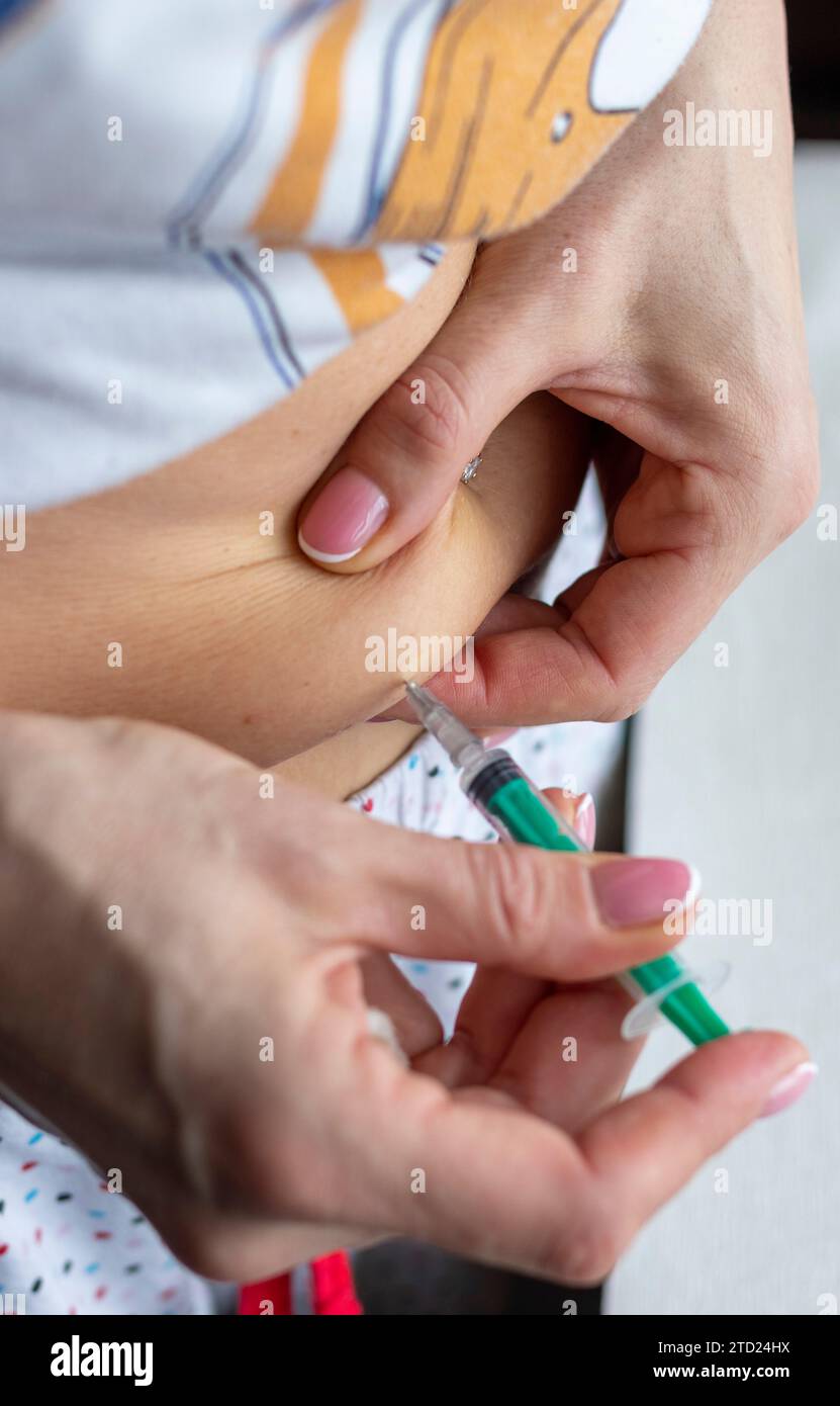 Ripresa ravvicinata della donna con belle mani, preparando la medicina ormonale e iniettandosi all'addome con il bottone a campanello perforato. Foto Stock Ripresa ravvicinata della donna con belle mani, preparando la medicina ormonale e iniettandosi all'addome con il bottone a campanello perforato. Foto Stock