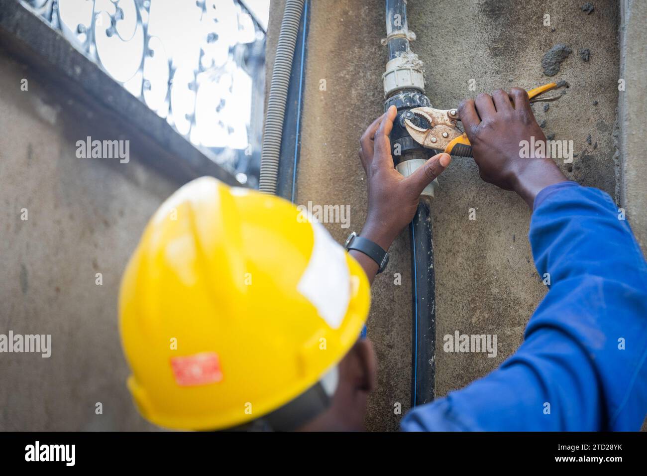 Primo piano delle mani di un idraulico intenzionato a svitare i bulloni dal sistema dell'acqua. Foto Stock