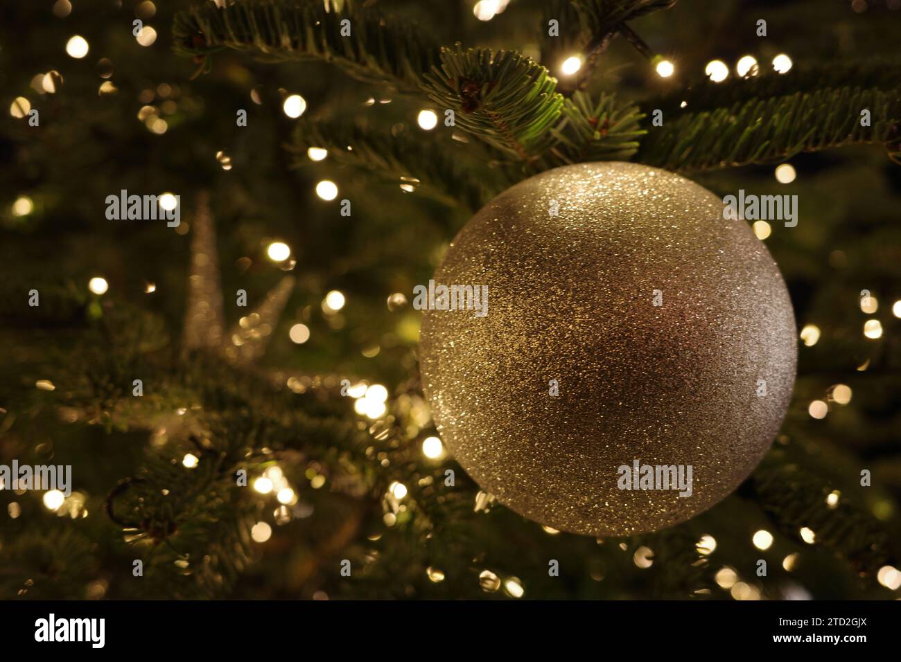 Bellissime luci natalizie, decorazioni e bauble sull'albero di Natale Foto Stock