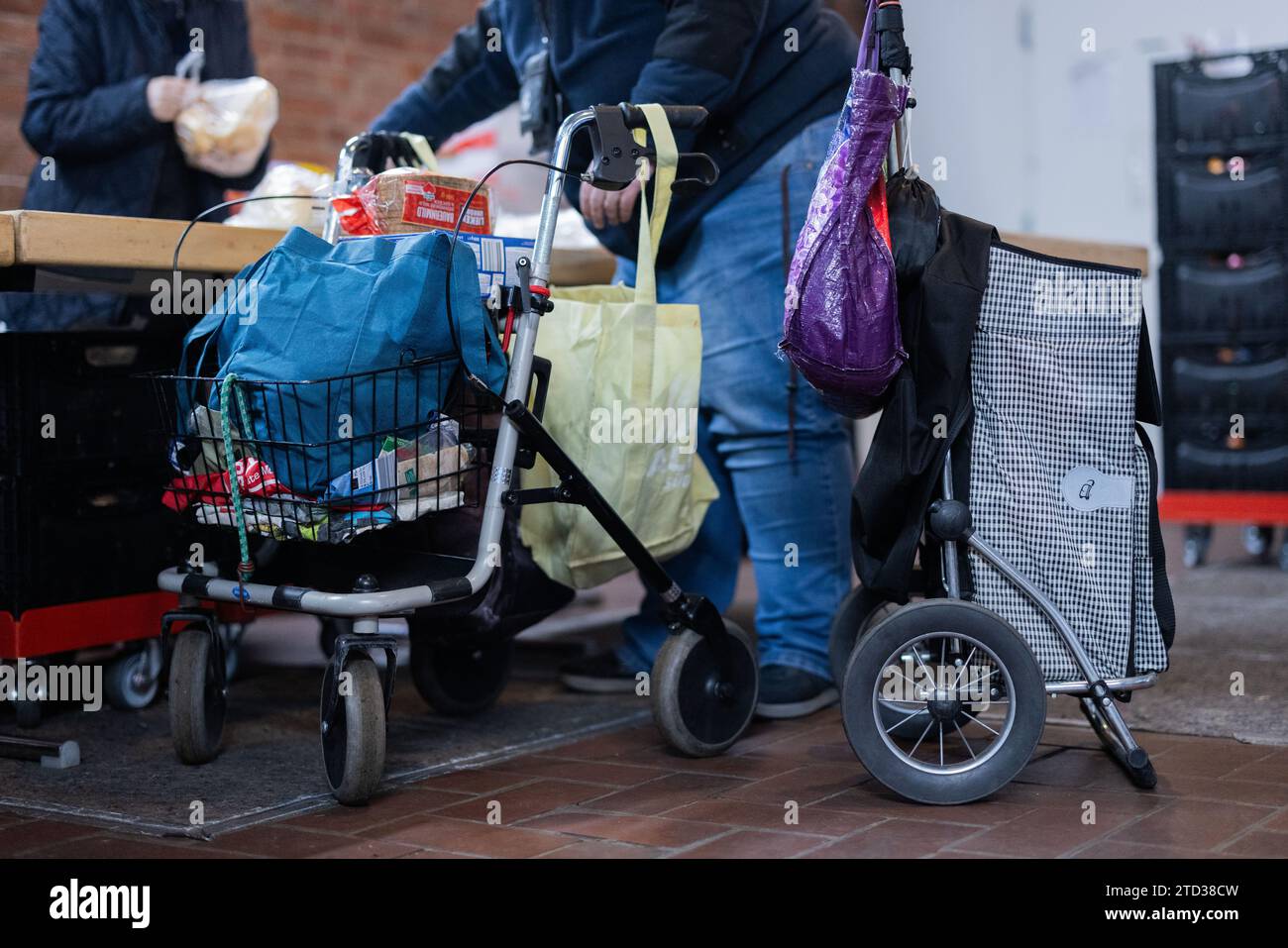 PRODUZIONE - 15 dicembre 2023, Renania settentrionale-Vestfalia, Oberhausen: Le persone bisognose ricevono cibo dalla banca alimentare. Le code davanti ai punti di distribuzione della banca alimentare, i volontari al limite della loro capacità e la domanda di cibo in continua crescita: Il sostegno a più di 600.000 persone bisognose in NRW sta raggiungendo i suoi limiti. Foto: Rolf Vennenbernd/dpa Foto Stock
