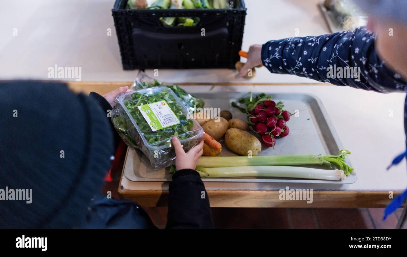 PRODUZIONE - 15 dicembre 2023, Renania settentrionale-Vestfalia, Oberhausen: Le persone bisognose ricevono cibo dalla banca alimentare. Le code davanti ai punti di distribuzione della banca alimentare, i volontari al limite della loro capacità e la domanda di cibo in continua crescita: Il sostegno a più di 600.000 persone bisognose in NRW sta raggiungendo i suoi limiti. Foto: Rolf Vennenbernd/dpa Foto Stock