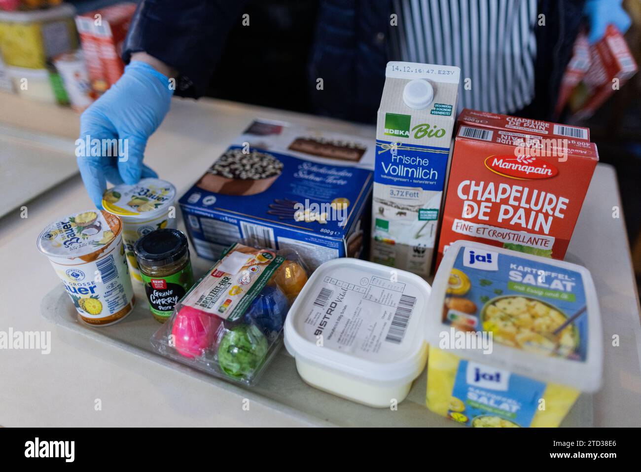 PRODUZIONE - 15 dicembre 2023, Renania settentrionale-Vestfalia, Oberhausen: Le persone bisognose ricevono cibo dalla banca alimentare. Le code davanti ai punti di distribuzione della banca alimentare, i volontari al limite della loro capacità e la domanda di cibo in continua crescita: Il sostegno a più di 600.000 persone bisognose in NRW sta raggiungendo i suoi limiti. Foto: Rolf Vennenbernd/dpa Foto Stock