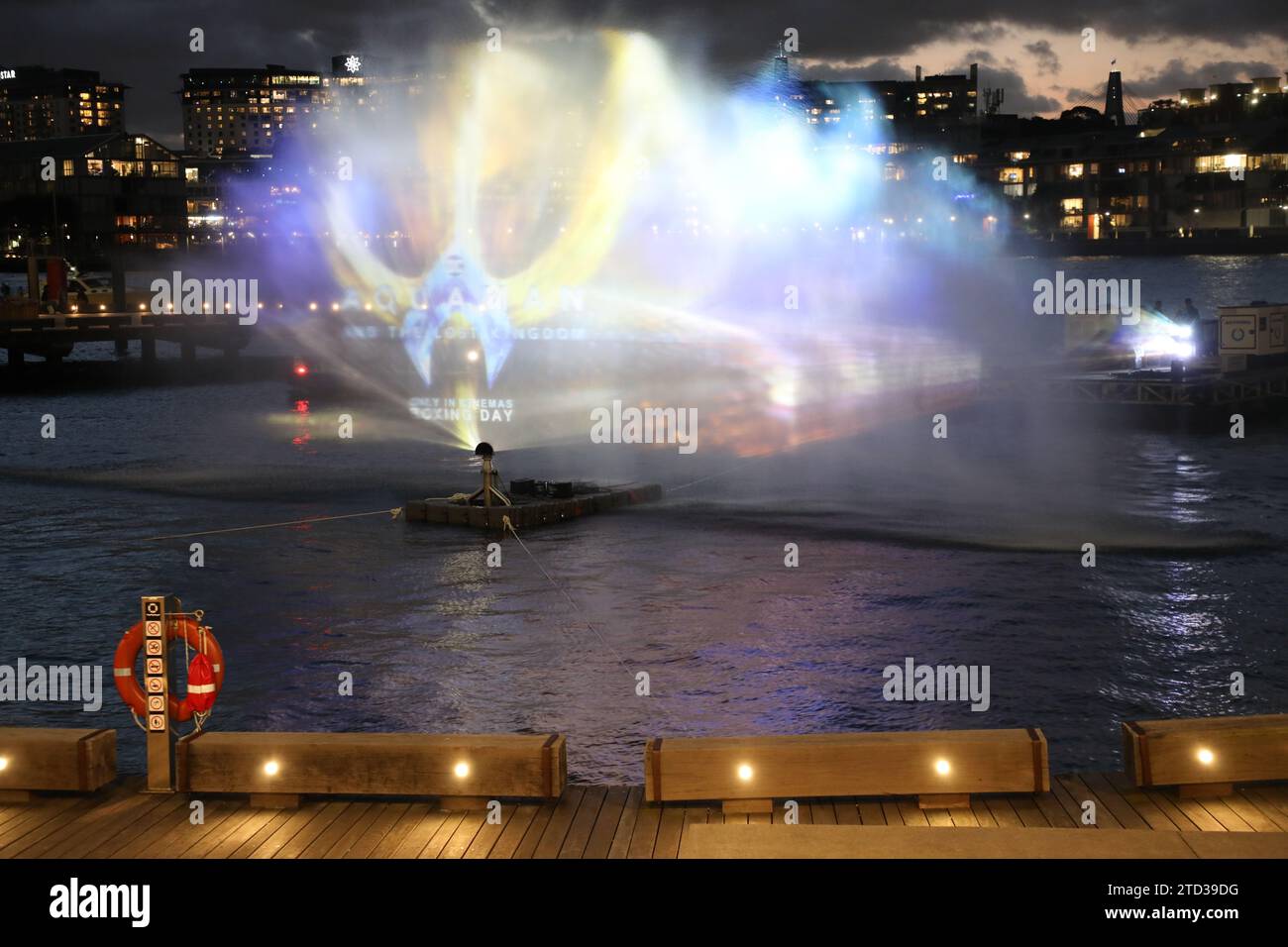 Sydney, Australia. 15 dicembre 2023. Per festeggiare l'uscita del sequel Aquaman del regista australiano James Wan, un tridente d'oro di 7 metri aprirà il terreno del lungomare di Watermans Cove, Barangaroo, da giovedì a domenica. E per la prima volta per la Warner Bros. In Australia, le riprese dell'avventura d'azione estiva saranno proiettate su una spettacolare parete d'acqua alta 9 m x 12 m di larghezza nella baia sul porto per una sola notte questo venerdì. Offrendo a fan e passanti un'anteprima del film prima della sua uscita il giorno di Santo Stefano, il filmato teaser verrà ripetuto ogni mezz'ora a partire da circa Foto Stock